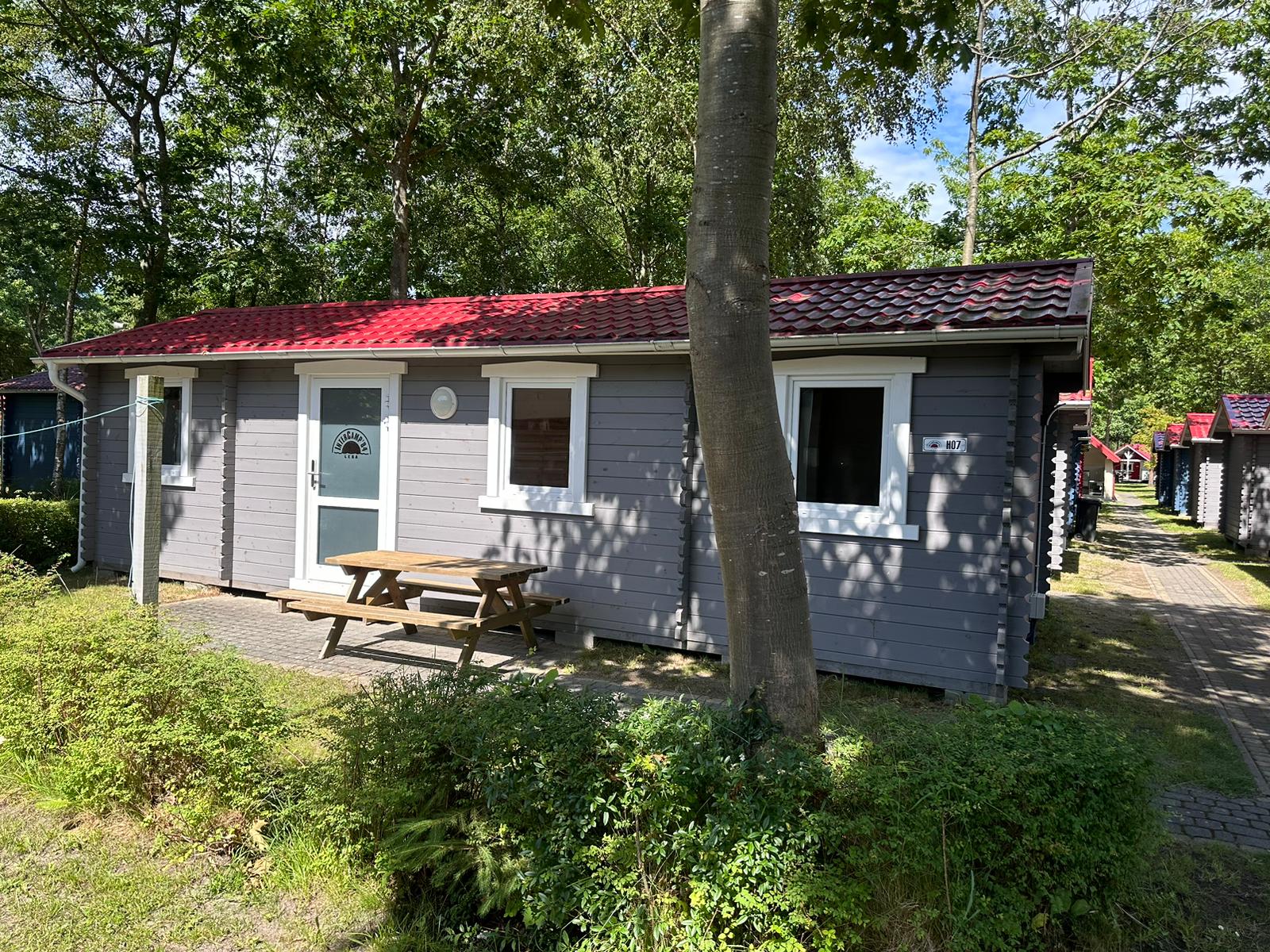 Domek letniskowy H07 na campingu InterCamp’84 Łeba – komfortowe zakwaterowanie w spokojnej, zielonej części pola campingowego.