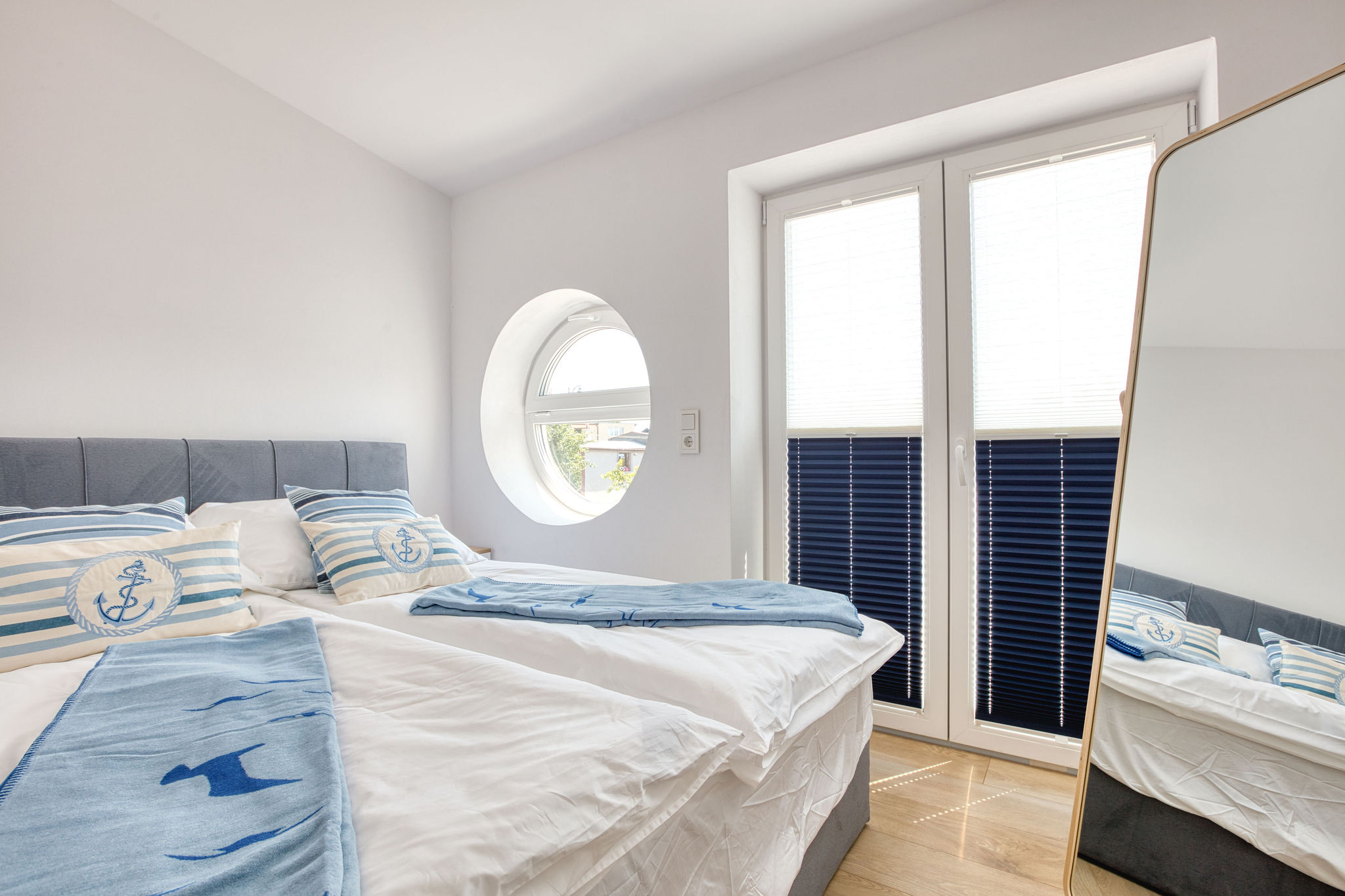 Elegancka sypialnia w stylu marynistycznym w apartamencie premium Villa Supreme Łeba – komfortowy nocleg nad Bałtykiem.